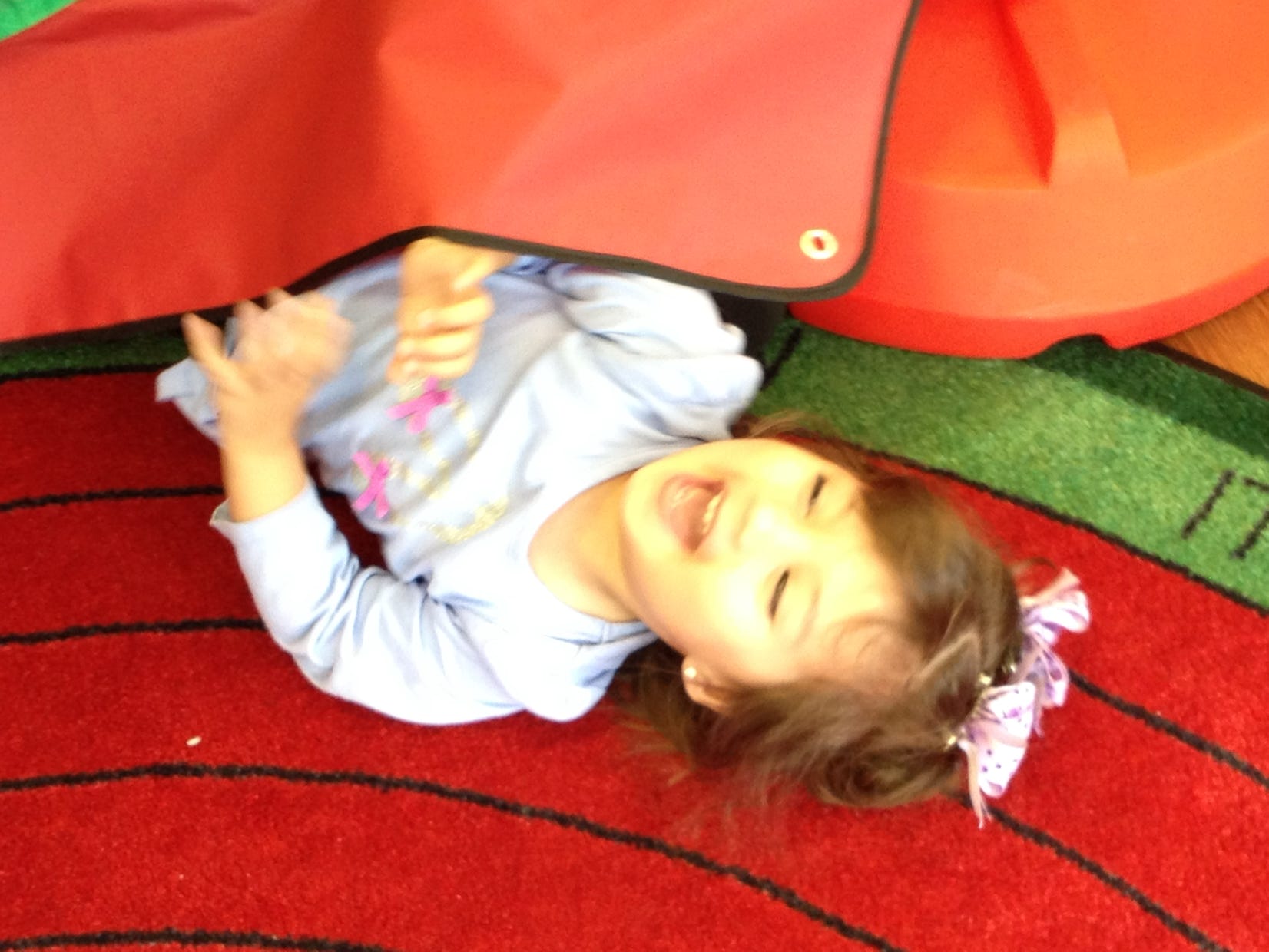Girl under a cover laughing